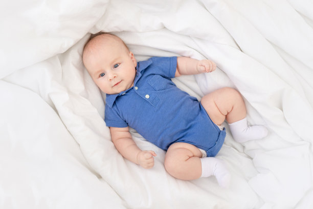 婴儿床上的男孩，快乐的新生儿在早上醒来或上床睡觉图片下载