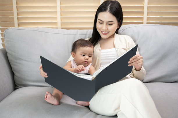 美丽的妈妈在家里给女儿读书图片下载