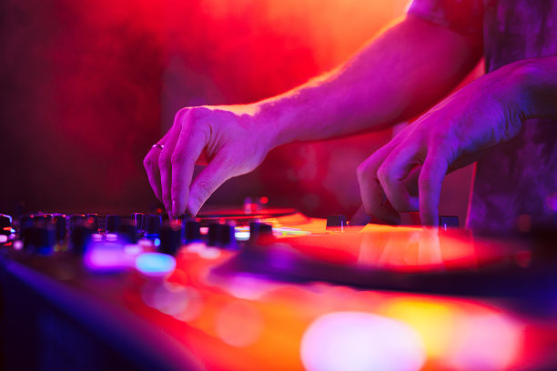 近距离的DJ手在DJ控制台混音在音乐会期间在俱乐部图片下载