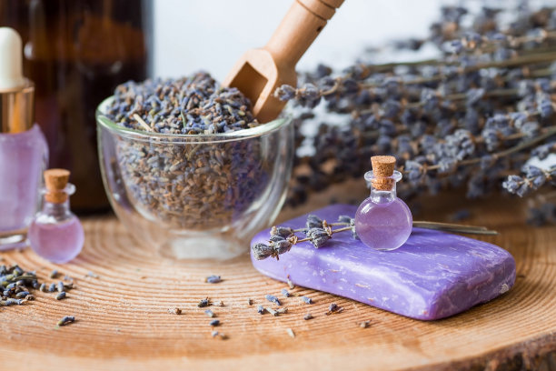 芳香疗法。按摩和水疗。化妆品瓶薰衣草精油，干花和薰衣草种子放在一个木架上。天然的身体化妆品。图片下载