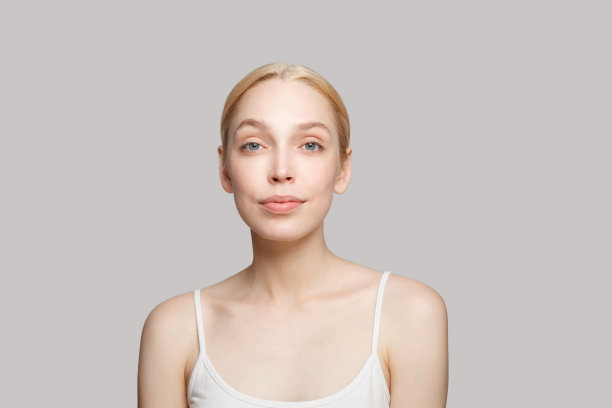 快乐的女人在白色背心微笑孤立的灰色背景。美容、化妆品、护肤、魅力图片下载