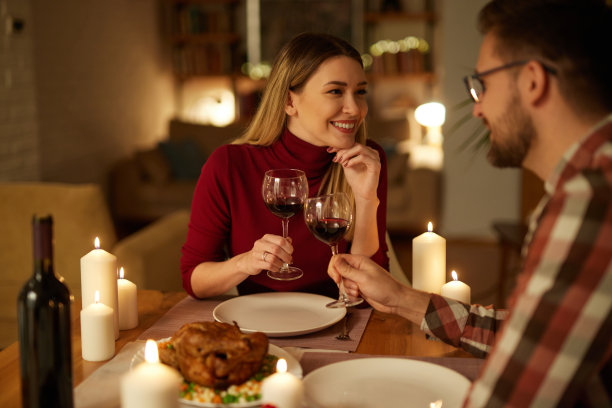 美丽的情侣在家里用蜡烛和红酒共进浪漫的晚餐图片下载