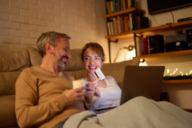 成熟的夫妇在家里用笔记本电脑和信用卡网购图片下载