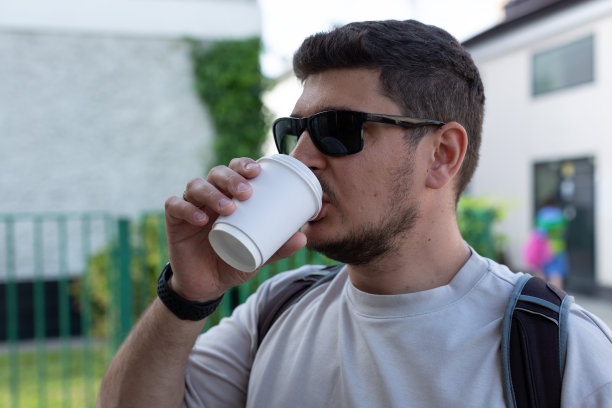 一名男子用一次性纸杯喝咖啡图片下载