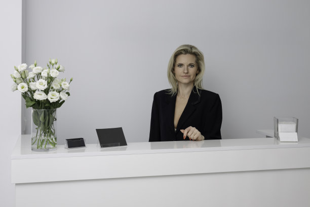 美丽的接待员欢迎病人到美容院图片下载