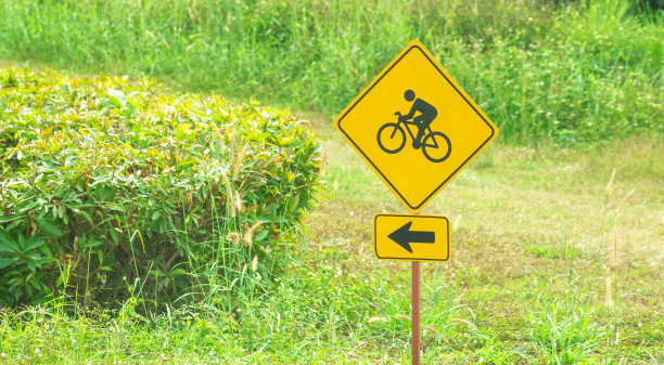 自行车标志上模糊自然背景，道路安全图片下载