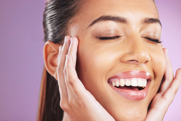 护肤，美容和女人用手在脸上美容，美容产品和皮肤病学。化妆品，化妆和快乐的女孩在紫色的背景为健康，面部治疗和水疗美学图片下载