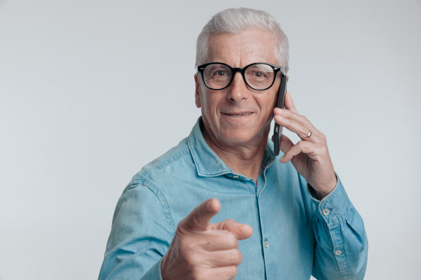 一位60多岁的老人正在打电话，一边用手指着对方图片下载