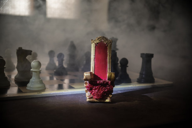 红色皇家椅子微型木桌。中世纪棋盘上的王座。棋牌游戏概念的经营理念和竞争理念的战略理念。有选择性的重点图片下载