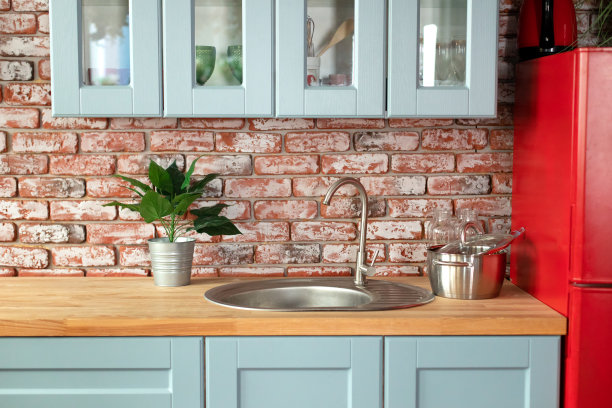 厨房有橱柜、抽屉和木制台面。室内的木制蓝色厨房立面，配有现代家具，红色冰箱，橱柜，烹饪水槽和铬水龙头，器皿。图片下载