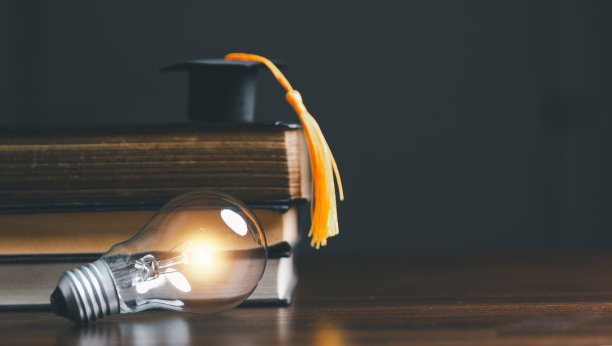 灯泡和带毕业帽的书。观念读书、求知、求新。创新与灵感，创意与闪烁的灯光，灵感的想法。图片下载