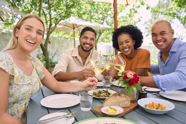 一群朋友在葡萄园餐厅享受户外用餐和葡萄酒的肖像图片下载