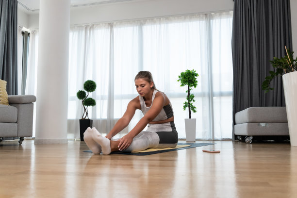 强壮的汗水和美丽的运动健身女孩在运动服做运动和家庭锻炼在她明亮宽敞的客厅与极简主义的内部。自我爱自信的女人练习图片下载