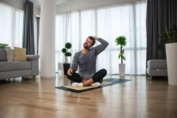 强壮的汗运动健身商务男子在运动服做运动和家庭锻炼在明亮宽敞的客厅与极简主义的内部。自爱自信的男性在工作前练习图片下载