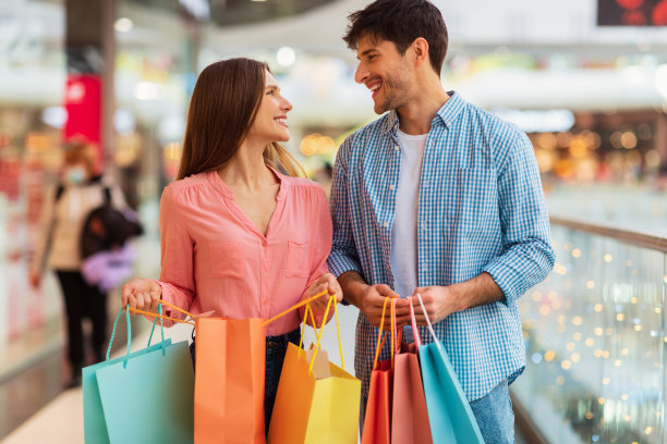 幸福的情侣拿着购物纸袋在商场购物图片下载
