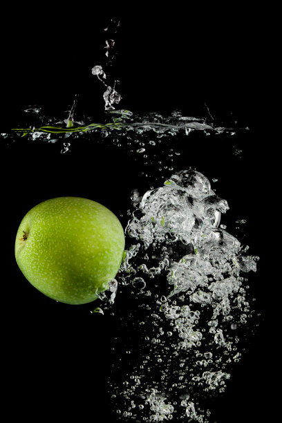 苹果在黑色背景下落入水中图片下载