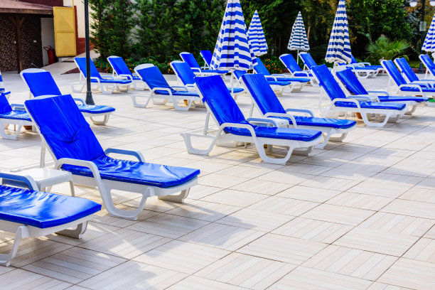 游泳池附近空无一人的躺椅和遮阳伞图片下载