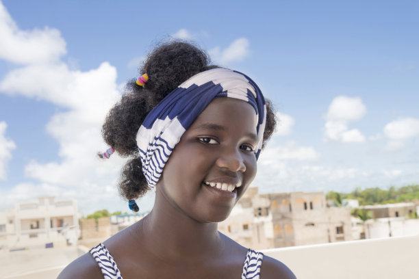 微笑的女孩站在阳台上，非洲发型和辫子，照片图片下载