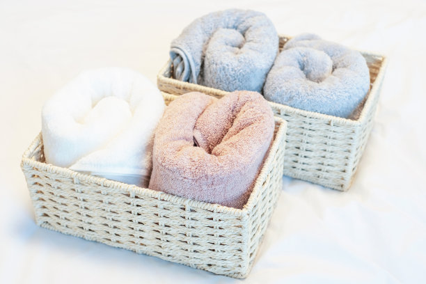 白底柳条容器中的毛巾特写，空间组织概念。图片下载