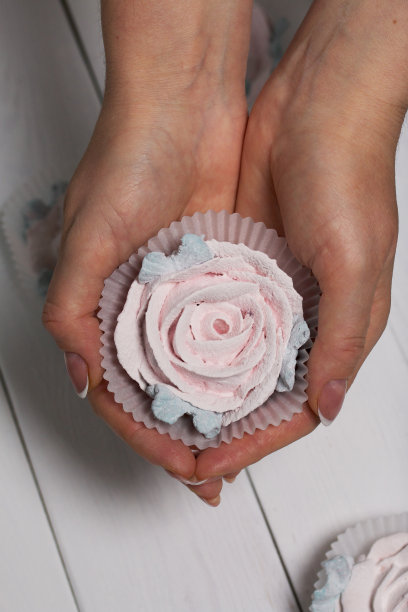 一个女人手里拿着自制的棉花糖。和风花。特写镜头。图片下载