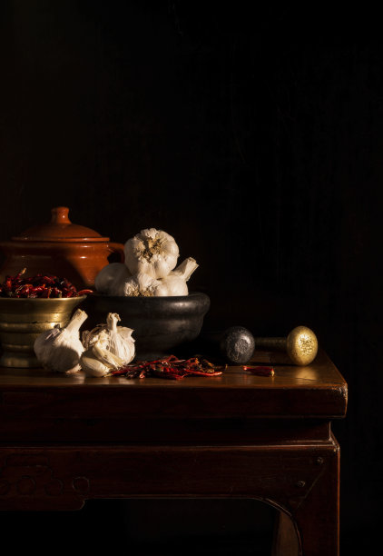静物画的干红辣椒，辣椒和大蒜与杵和臼在黑色背景图片下载