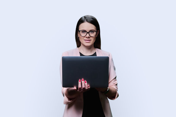 微笑的年轻女商人与笔记本电脑的肖像，在白色背景图片下载