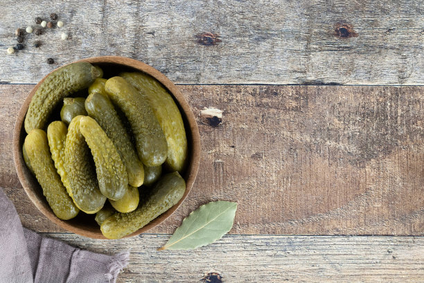 腌黄瓜在木碗与香料的木制背景。腌黄瓜。前视图。副本的空间。图片下载