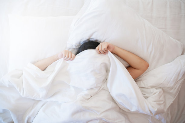 懒女人早上睡在床上。图片下载