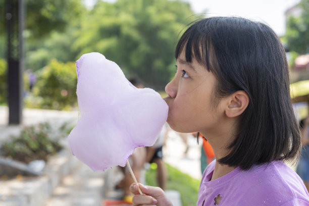 可爱的亚洲女孩在户外吃棉花糖图片下载