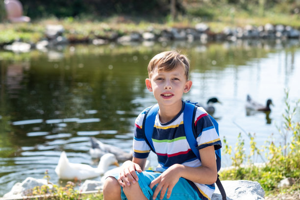 一个男孩坐在岩石上的肖像图片下载