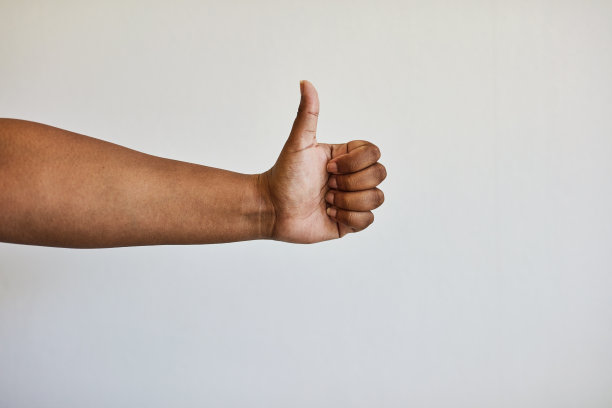 手语、协议符号和竖起大拇指的手被隔离在演播室的白色背景上。感谢你，激励你，用一个手势在墙上表达你的评价、意见或满意图片下载