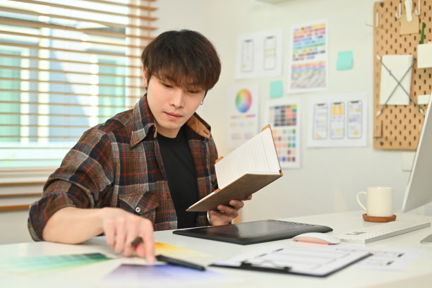 年轻的亚洲男性设计师，在创意办公室规划移动应用程序开发原型线框设计。图片下载