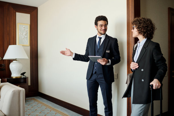 年轻自信的酒店经理向女客人展示房间图片下载