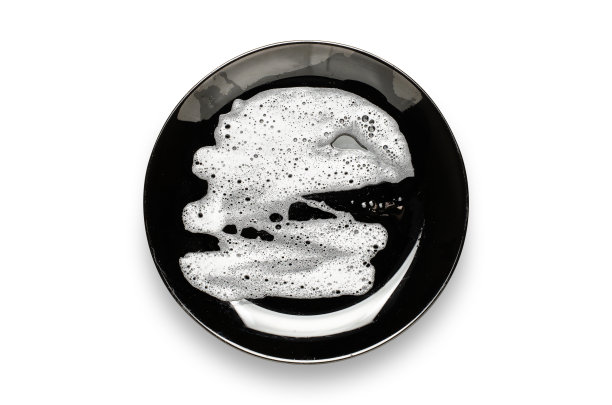 有肥皂泡沫的黑色盘子。饭后洗碗。孤立在白色背景上图片下载