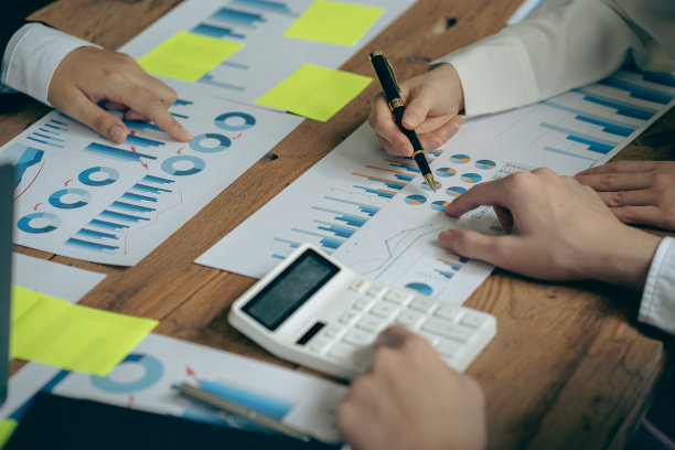 业务团队会议，合作讨论财务数据分析和营销业务战略项目。在办公室展示财务图表文件，特写照片图片下载