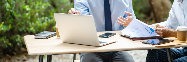 团队高管坐在室外工作场所讨论业务模式。图片下载