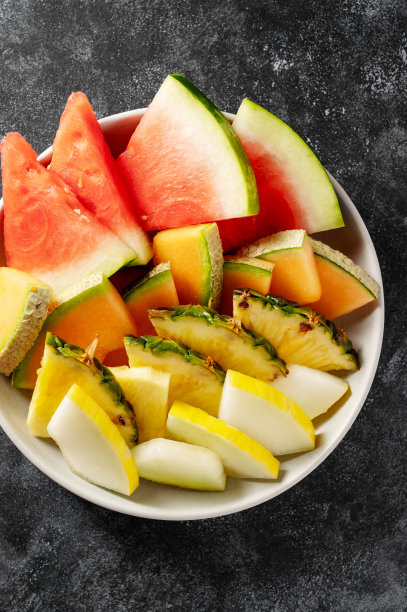 近距离水果拼盘开胃菜，西瓜，菠萝，甜瓜和草莓。暗的背景图片下载