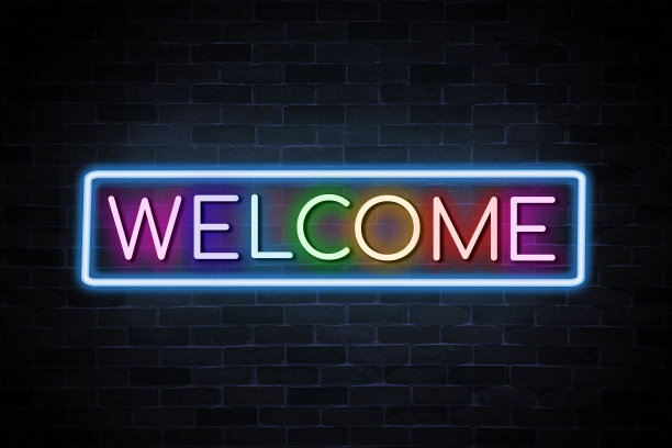 欢迎文字霓虹灯横幅在砖墙背景。图片下载