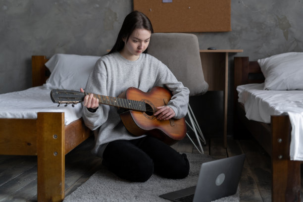 女学生在家里演奏原声吉他，年轻的亚洲音乐家女孩的生活方式。图片下载