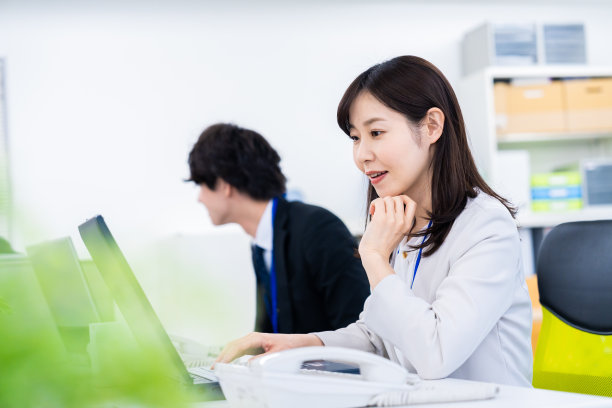 一个微笑着在办公桌前工作的女人图片下载