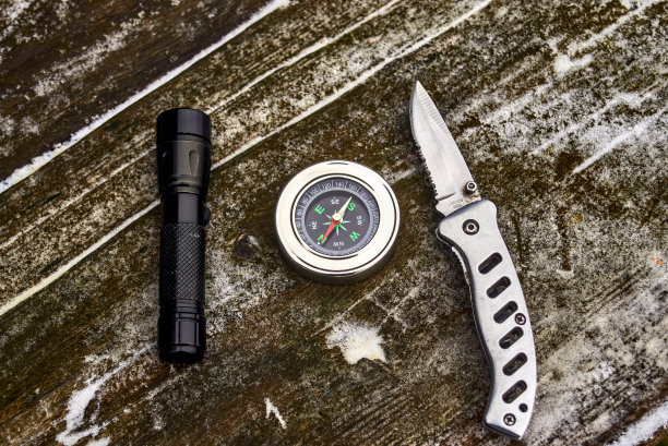 手电筒、指南针和木头上的刀图片下载