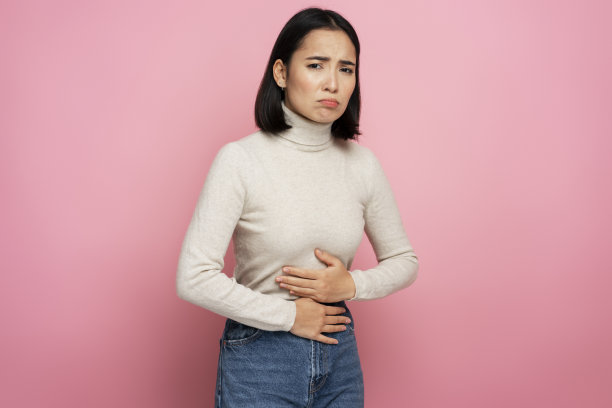 肖像的妇女紧抓肚子遭受胃痛，胃炎或便秘图片下载