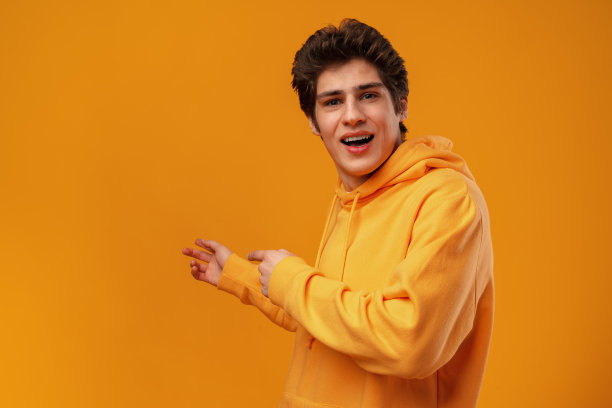 年轻英俊的男子在蓝色的背景指向一边图片下载