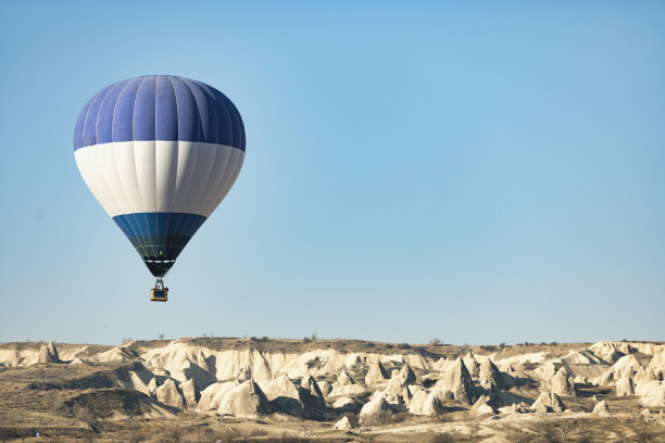 热气球飞过卡帕多西亚的群山图片下载