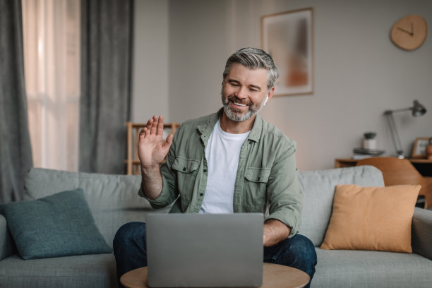 快乐的老欧洲男子胡须有视频通话，挥手和远程聊天图片下载
