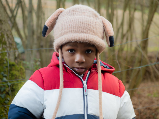 微笑的非裔美国孩子穿着温暖的羊毛帽在秋冬户外日落图片下载
