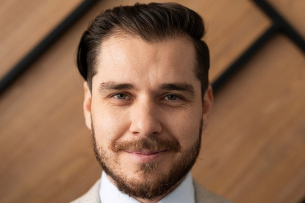 特写肖像的一个强壮的大胡子商人的背景下的木质纹理办公室墙图片下载