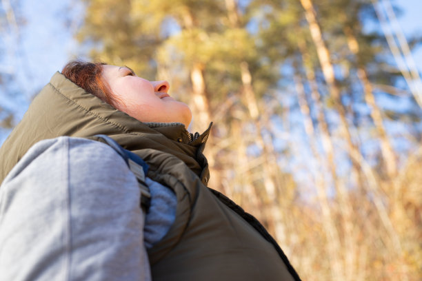 旅行者女人享受自然感觉平静和放松仰望天空，美丽的自然围绕着她。图片下载