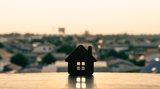 木头桌子上的房子模型。房产中介提供房屋、财产保险和保障、经济适用房等概念图片下载