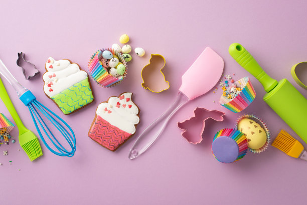 复活节烹饪概念。厨房用具的俯视图照片搅拌擀面杖刷硅胶锅铲复活节鸡蛋蛋糕形状姜饼纸烘焙模具和洒在孤立的紫丁香背景图片下载